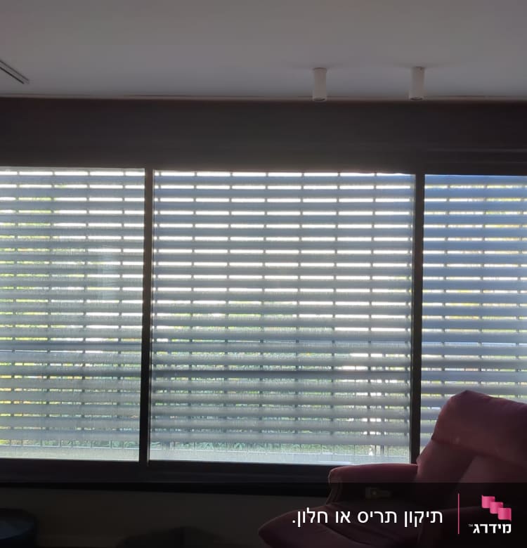 תריסים אופקיים סגורים על חלון גדול בסלון